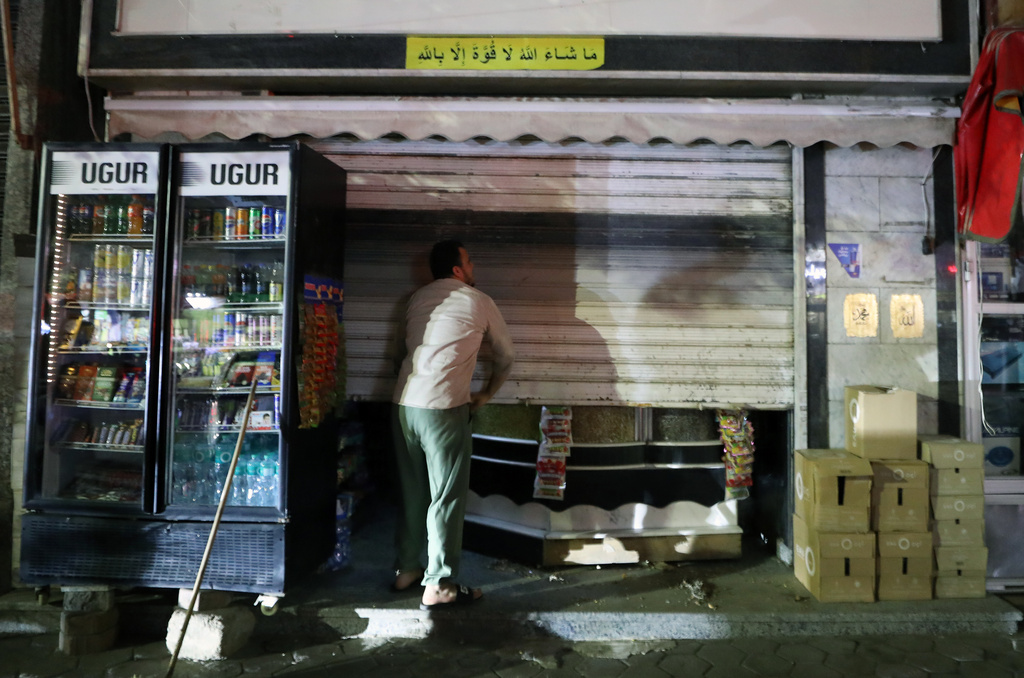 A man closed his shop after earlier closing hours applied, as part of a series of measures the government has taken to mitigate the fallout of the U.S. and Israeli war against Iran, in Cairo, Egypt, late Saturday, March 28, 2026. (AP Photo/Khaled Elfiqi)