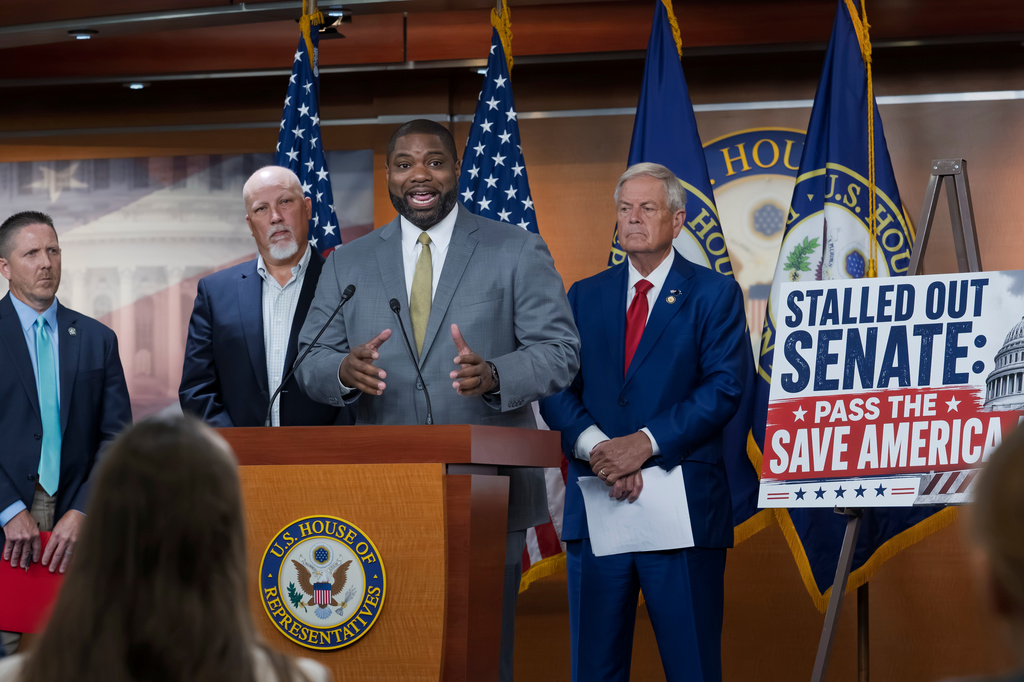 Rep. Byron Donalds, R-Fla., center, flanked by Rep. Chip Roy, R-Texas, left, and Rep. Ralph Norman, R-S.C., right, speaks to reporters as the conservative House Freedom Caucus slams the Senate for not acting on the Save America Act at the Capitol in Washington, Thursday, June 25, 2026. (AP Photo/J. Scott Applewhite)