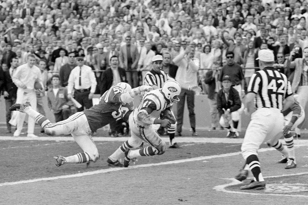 FILE - New York Jets fullback Matt Snell, center, runs the ball as Baltimore linebacker Dennis Gaubatz, left, defends during the NFL football Super Bowl 3 in Miami, Jan. 12, 1969. (AP Photo, File)