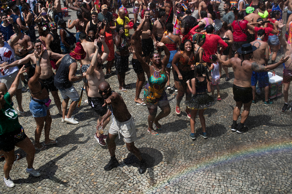 FILE - Revelers cool off with the help of spray truck showering water into the crowd of partiers amid the extreme heat, Feb. 15, 2025. (AP Photo/Bruna Prado, File)