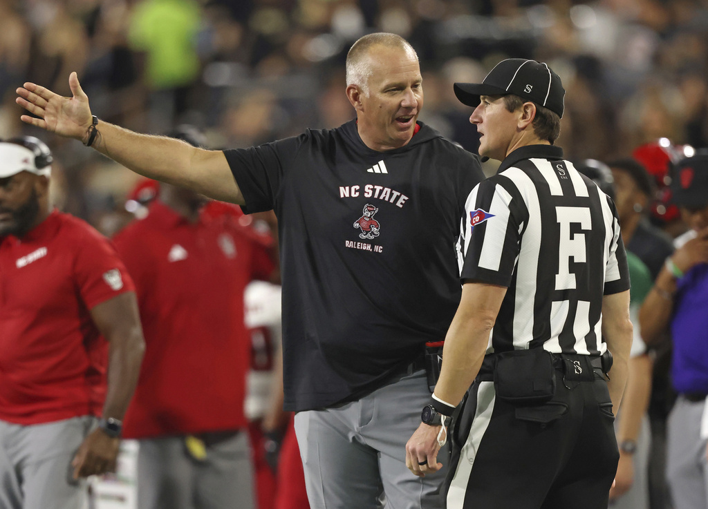 North Carolina State head coach Dave Doeren, front left, talks with field judge Hugh Brown, front right, during an NCAA college football game against Wake Forest, Thursday, Sept. 11, 2025, in Winston-Salem, N.C. (Walt Unks/The Winston-Salem Journal via AP)