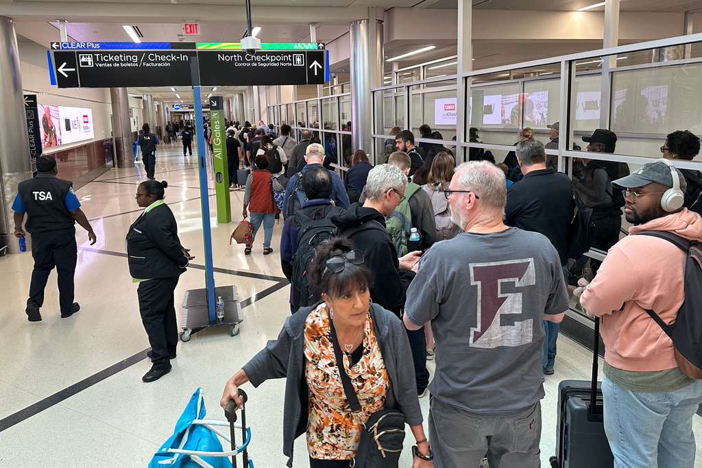 Passengers wait outside a Transportation Security Administration checkpoint at Hartsfield-Jackson Atlanta International Airport on Saturday, March, 21, 2026, (AP Photo/Jeff Amy)