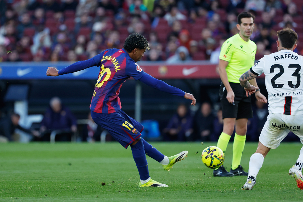 Barcelona's Lamine Yamal, left, scores his side's 2nd goal during the Spanish La Liga soccer match between Barcelona and Mallorca in Barcelona, Spain, Saturday, Feb. 7, 2026. (AP Photo/Joan Monfort)