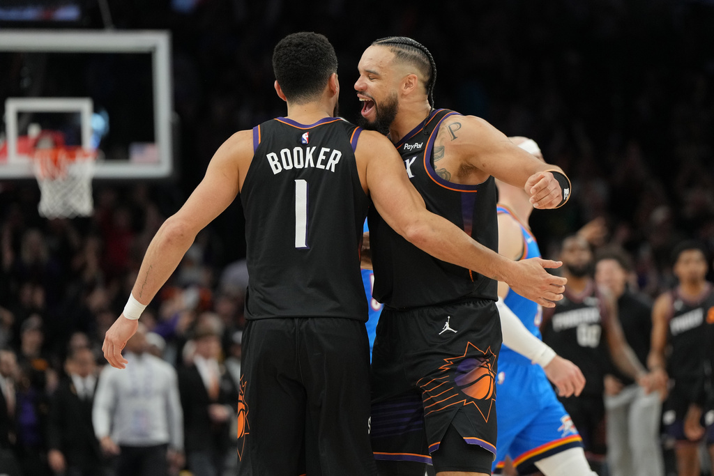 Phoenix Suns guard Devin Booker, left, celebrates with forward Dillon Brooks after hitting the winning shot against the Oklahoma City Thunder during the second half of an NBA basketball game, Sunday, Jan. 4, 2026, in Phoenix. (AP Photo/Rick Scuteri)