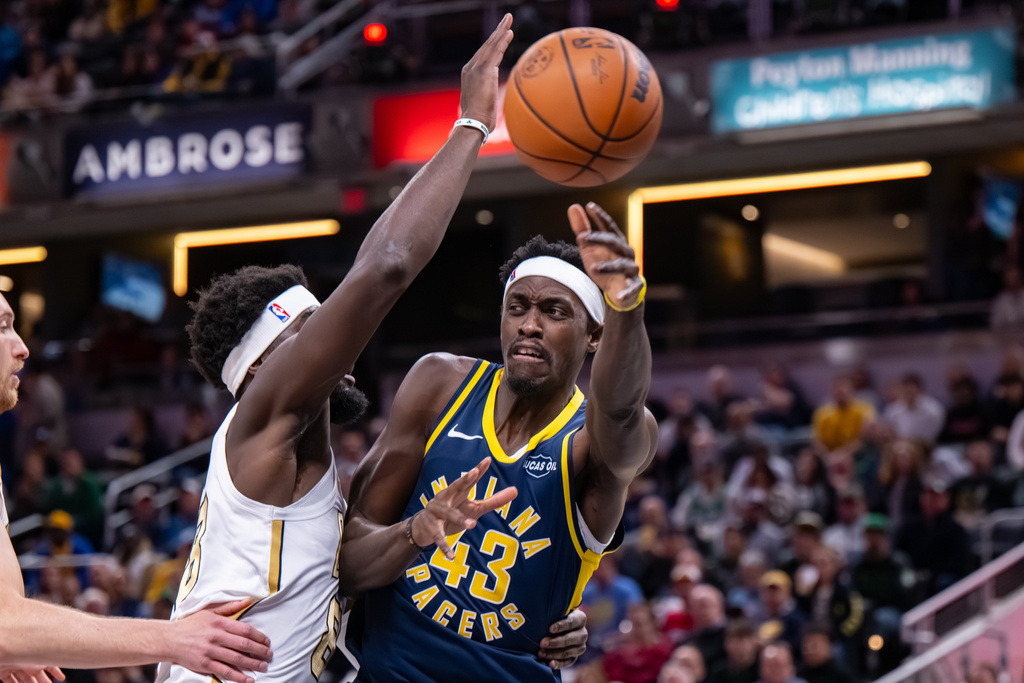 Indiana Pacers forward Pascal Siakam (43) makes a pass while being defended by Boston Celtics center Neemias Queta during the first half of an NBA basketball game in Indianapolis, Monday, Jan. 12, 2026. (AP Photo/Doug McSchooler)