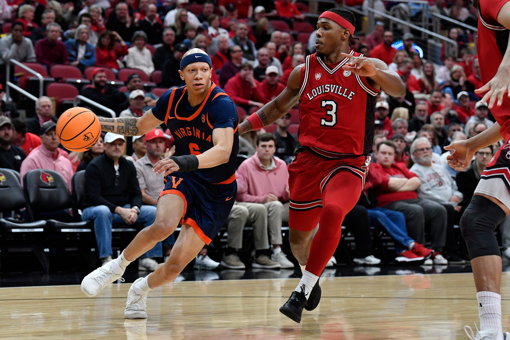 Virginia guard Jacari White (6) drives past Louisville guard Ryan Conwell (3) during the first half of an NCAA college basketball game in Louisville, Ky., Tuesday, Jan. 13, 2026. (AP Photo/Timothy D. Easley)