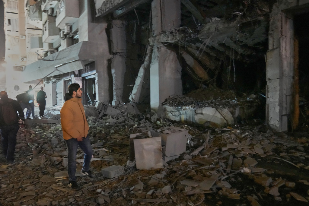 A man views the destroyed branch of Al-Qard Al-Hassan, a non-bank financial institution run by Hezbollah, that was hit by an Israeli airstrike in central Beirut, Lebanon, Thursday, March 12, 2026. (AP Photo/Hussein Malla)