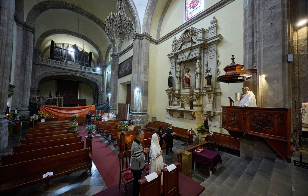 Vinicio Cruz and Carmen Chavez get married during a ceremony by Father Juan Carlos Guerrero inside San Juan de Dios church in Mexico City, Friday, Sept. 19, 2025. The church withstood the 8.0 earthquake of 1985, however, its structure was severely damaged in 2017 and it was forced to shut down and reopened in late 2024 after most of its restoration was completed. (AP Photo/Ginnette Riquelme)