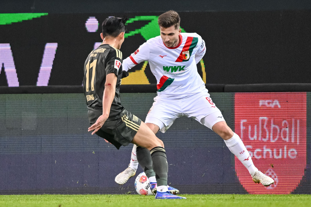 Augsburg's Elvis Rexhbeçaj. right, and Berlin's Woo-yeong Jeong in action during the Bundesliga soccer match between FC Augsburg and FC Union Berlin in Augsburg, Germany, Thursday Jan. 15, 2026. (Harry Langer/dpa via AP)