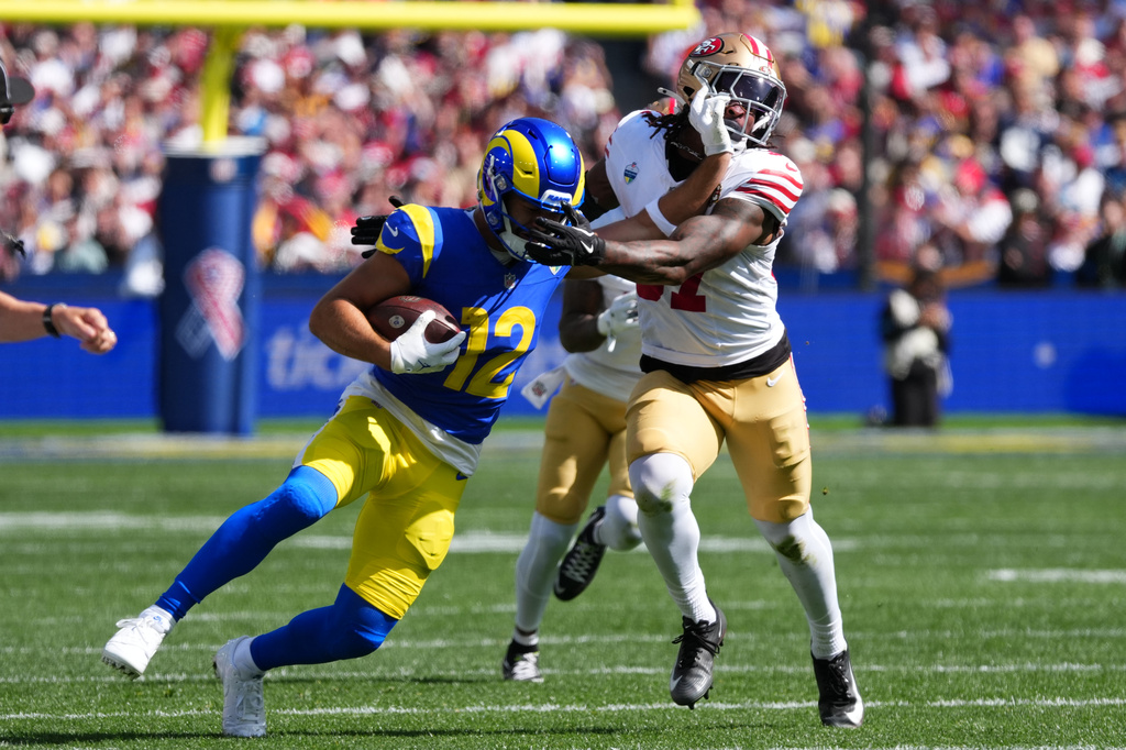 Los Angeles Rams wide receiver Puka Nacua runs pass San Francisco 49ers safety Ji'ayir Brown during the first half of an NFL football game, Friday, Sept. 11, 2026, in Melbourne, Australia. (AP Photo/Scott Barbour)