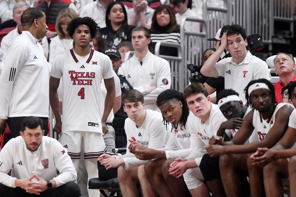 Texas Tech athletic trainer Mike Neal, top left, speaks to Texas Tech guard Christian Anderson (4) during the second half of an NCAA college basketball game against Kansas, Monday, Feb. 2, 2026, in Lubbock, Texas. (AP Photo/Annie Rice)