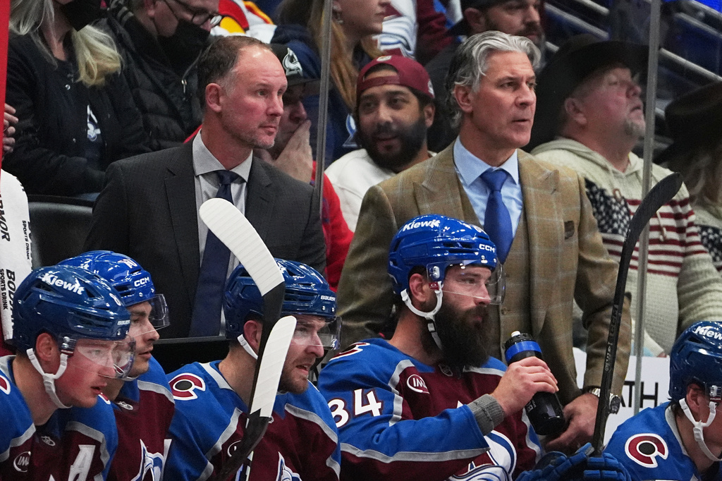 Colorado Avalanche head coach Jared Bednar, back right, and assistant coach Nolan Pratt, back left, look on from the team box in the second period of an NHL hockey game against the Vancouver Canucks Tuesday, Dec. 2, 2025, in Denver. (AP Photo/David Zalubowski)