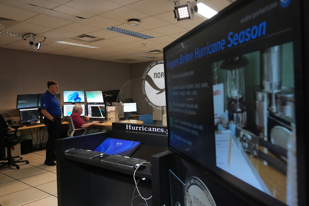 FILE - Senior hurricane specialists Eric Blake, left, and Richard Pasch, right, work at the National Hurricane Center on the first day of hurricane season, June 1, 2026, in Miami. (AP Photo/Lynne Sladky, File)