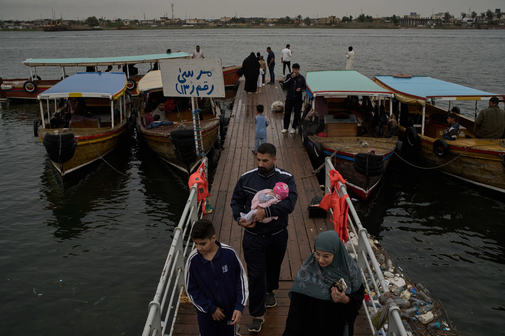 A family arrives from a boat trip on the Shatt al-Arab River, in Basra, Iraq, Thursday, March 26, 2026. (AP Photo/Leo Correa)
