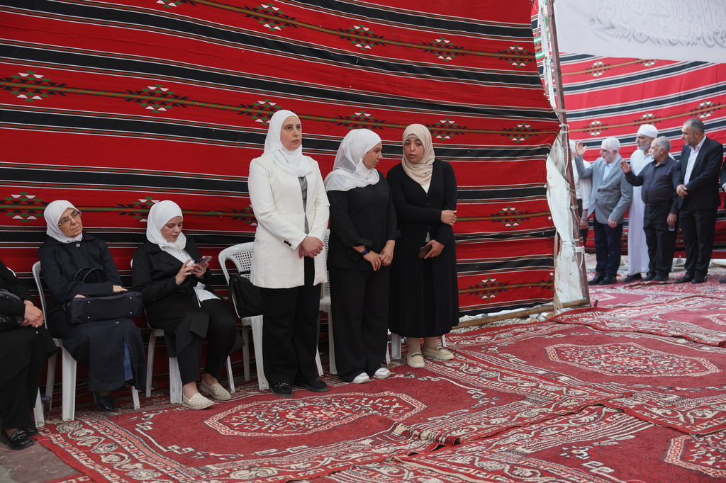 Residents gather to mourn former chess champion Rania al-Abbasi and her family, who disappeared 13 years ago, after relatives announced Monday they had evidence the family was killed by pro-government gunmen in 2013, in Damascus, Syria, Tuesday, June 2, 2026. (AP Photo/Ghaith Alsayed)