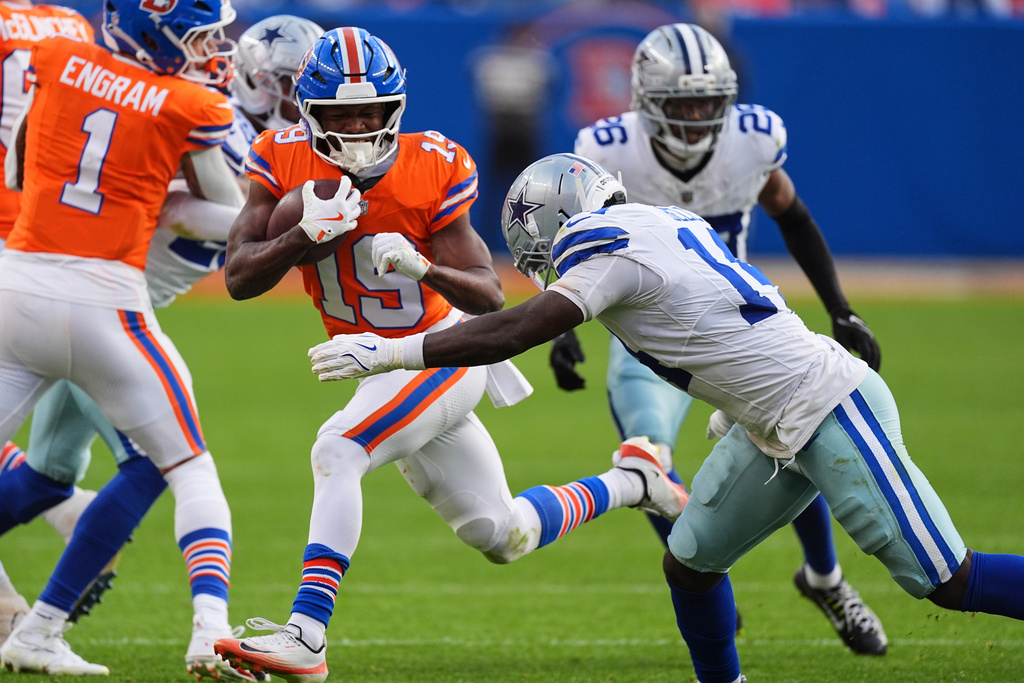 Denver Broncos wide receiver Marvin Mims Jr. (19) attempts to get past Dallas Cowboys safety Markquese Bell (14) in the second half of an NFL football game Sunday, Oct. 26, 2025, in Denver. (AP Photo/David Zalubowski)
