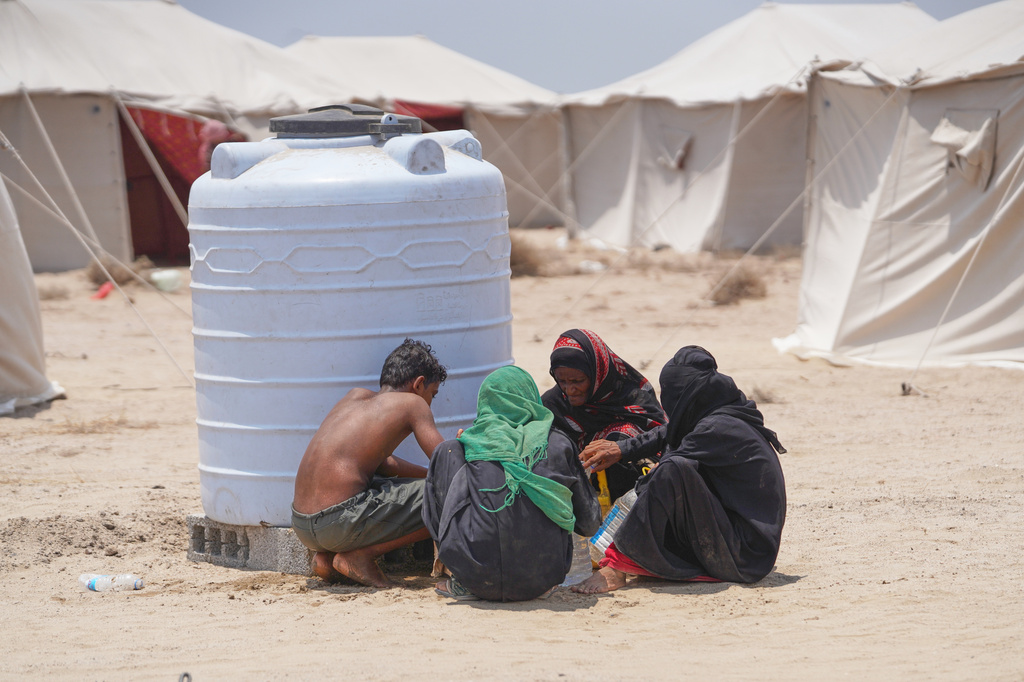 Displaced Yemenis chat at Al-Firdaws camp in Ras Imran, just outside Aden, Yemen, Monday, Sept. 14, 2026. (AP Photo/Abdulnasser Alseddik)