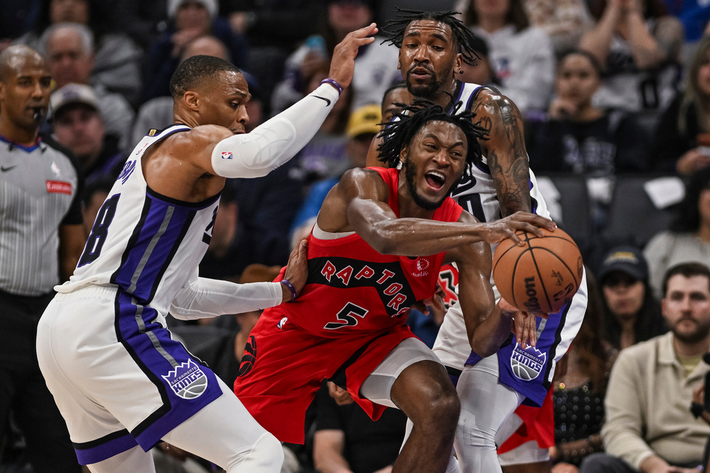 Toronto Raptors guard Immanuel Quickley (5) is fouled by Sacramento Kings guard Malik Monk (0) during the first half of an NBA basketball game, Wednesday, Jan. 21, 2026, in Sacramento, Calif. (AP Photo/Justine Willard)