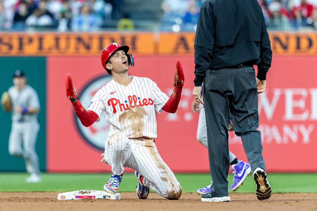 Philadelphia Phillies' Trea Turner, left, reacts to the call by umpire Nic Lentz after being called out at second base in the fourth inning of a baseball game against the Colorado Rockies, Saturday, May 9, 2026, in Philadelphia. (AP Photo/Laurence Kesterson)