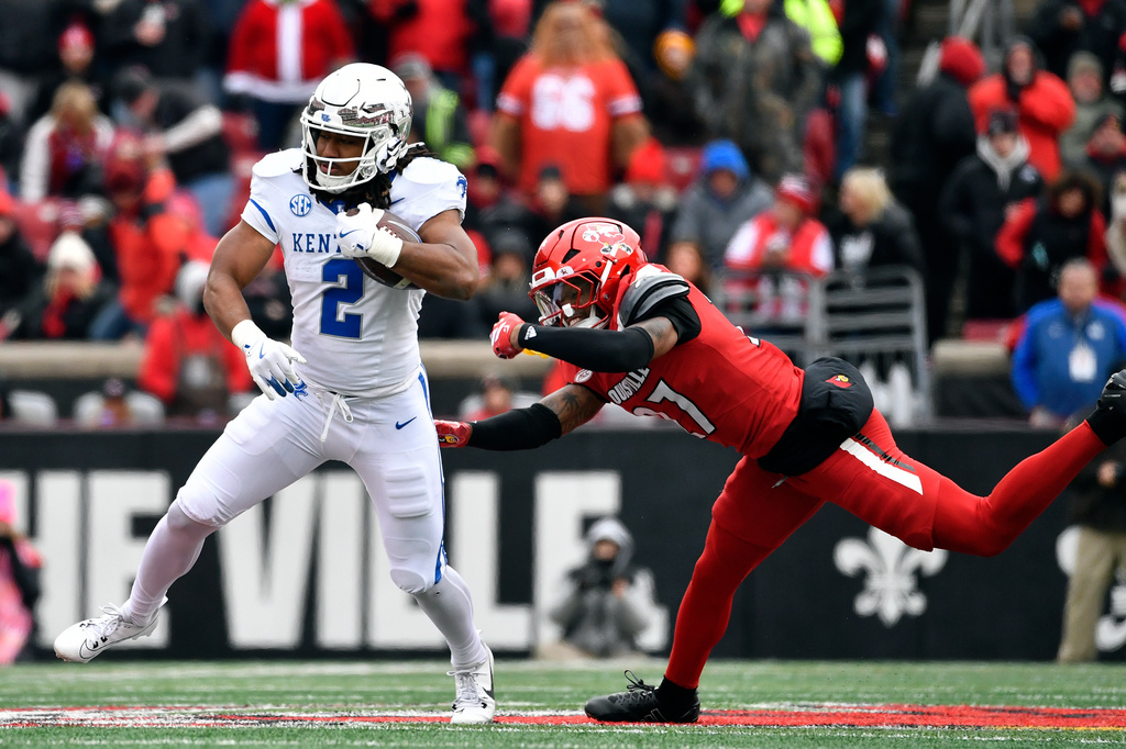 FILE - Kentucky running back Dante Dowdell (2) avoids the tackle attempt by Louisville defensive back Jojo Evans Jr. (27) during the second half of an NCAA college football game in Louisville, Ky., Nov. 29, 2025. (AP Photo/Timothy D. Easley, File)