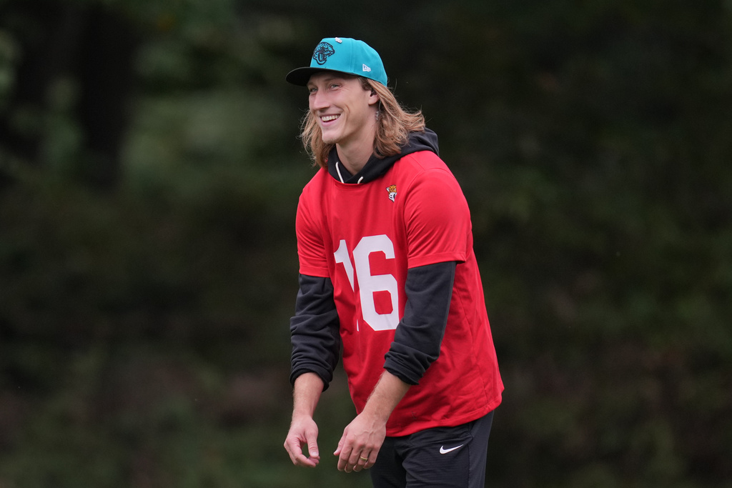 Jacksonville Jaguars quarterback Trevor Lawrence (16) smiles during an NFL football practice at The Grove in Watford, England, Wednesday, Oct. 15, 2025. (AP Photo/Kin Cheung)