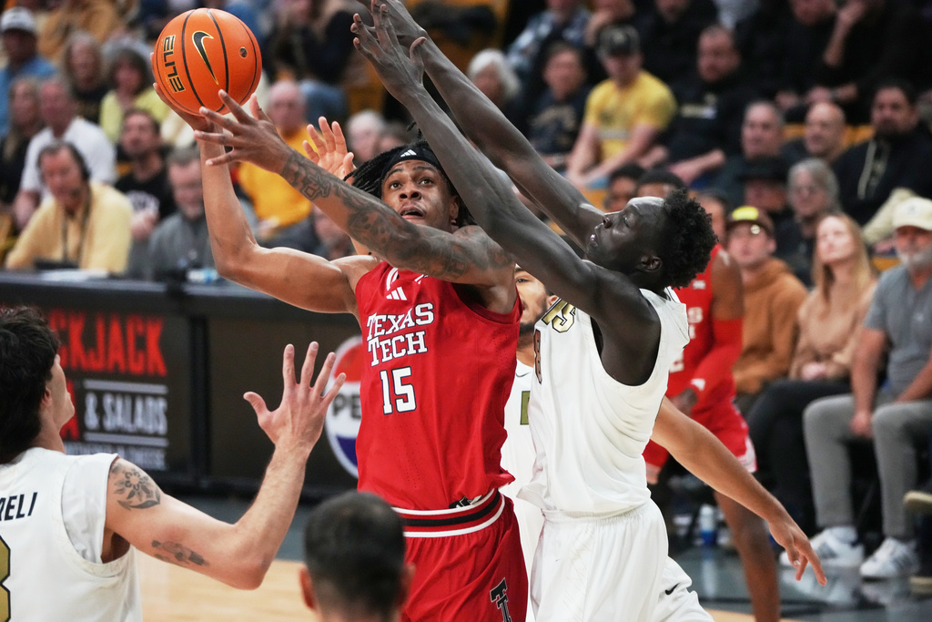 Texas Tech forward JT Toppin, center, goes up for a basket as Colorado forward Alon Michaeli, left, and forward Bangot Dak defend in the first half of an NCAA college basketball game Saturday, Jan. 10, 2026, in Boulder, Colo. (AP Photo/David Zalubowski)