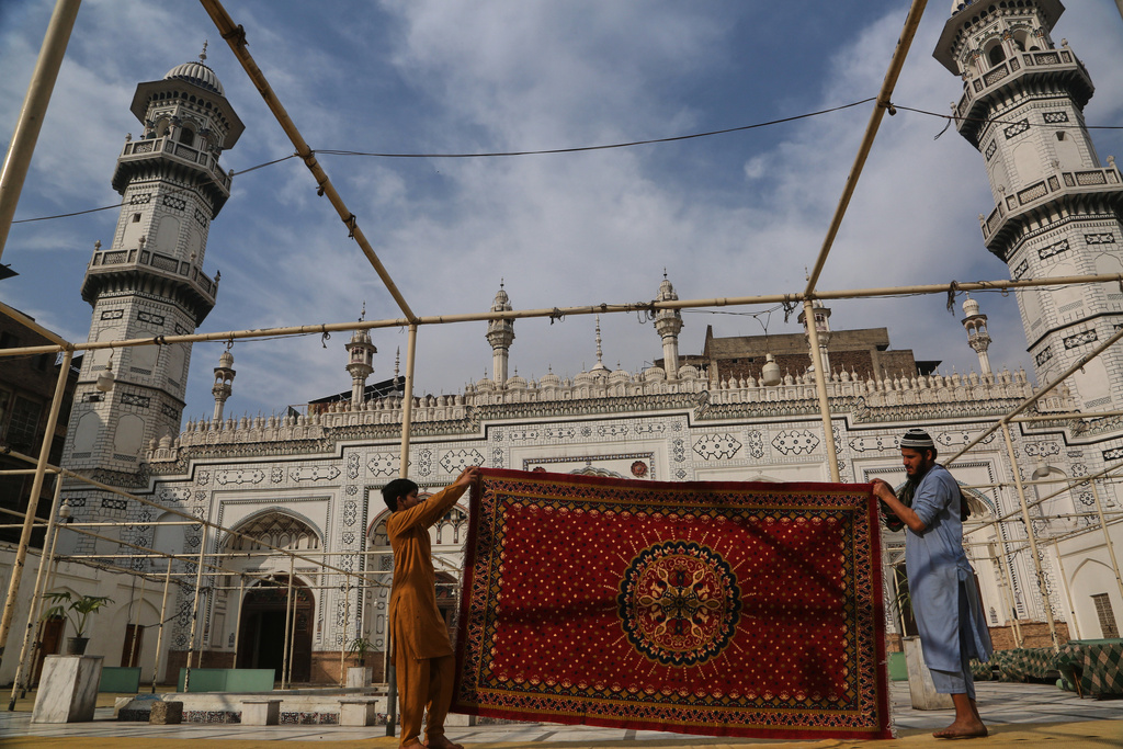 Workers clean carpet at the historic Mahabat Khan mosque in preparation for the upcoming Muslim fasting month of Ramadan, in Peshawar, Pakistan, Monday, Feb. 16, 2026. (AP Photo/Muhammad Sajjad)
