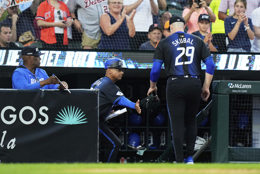 Detroit Tigers starting pitcher Tarik Skubal, right, is greeted by third base coach Joey Cora after being pulled out during the fifth inning of a baseball game against the Los Angeles Angels, Friday, Aug. 8, 2025, in Detroit. (AP Photo/Ryan Sun)