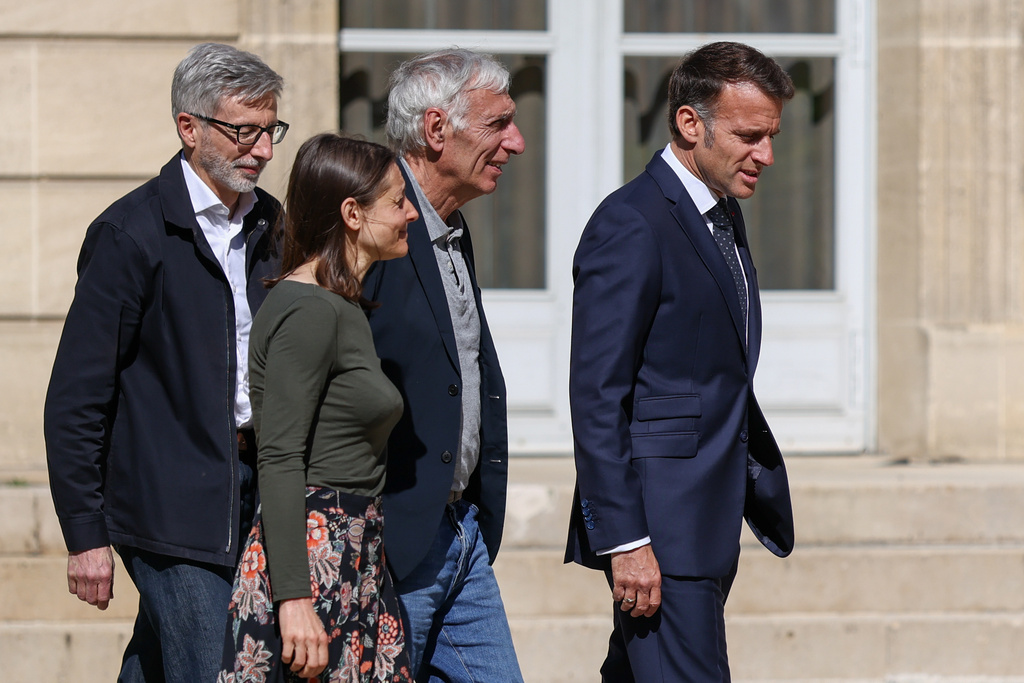 French President Emmanuel Macron, right, walks with Jacques Paris, second from right, and Cecile Kohler, third from right, French nationals who was freed by Iran with Cecile Kohler after three and a half years in detention, and French ambassador to Iran Pierre Cochard, left, at the Elysee Palace in Paris, France, April 8, 2026. (Tom Nicholson/Pool Photo via AP)