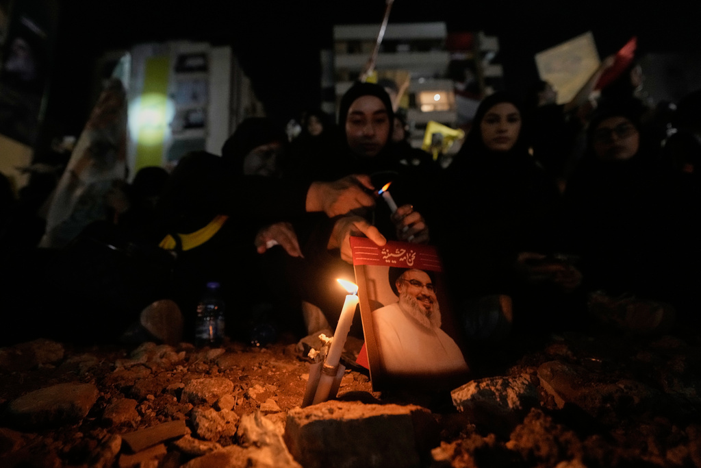 A candle illuminates an image of Hezbollah leader Hassan Nasrallah during a gathering at the site where he was killed in Israeli airstrikes on Sept. 27, 2024, a day before the first anniversary of his death, in the Haret Hreik suburb south of Beirut, Lebanon, Friday, April 26, 2025. (AP Photo/Hassan Ammar)