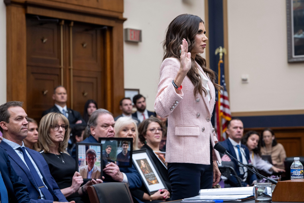 Bryon Norm, left, watches as his wife, Homeland Security Secretary Kristi Noem, as she is sworn in before testifying in front of a House Judiciary Committee hearing on the oversight of the Department of Homeland Security, Wednesday, March 4, 2026 in Washington. (AP Photo/Kevin Wolf)