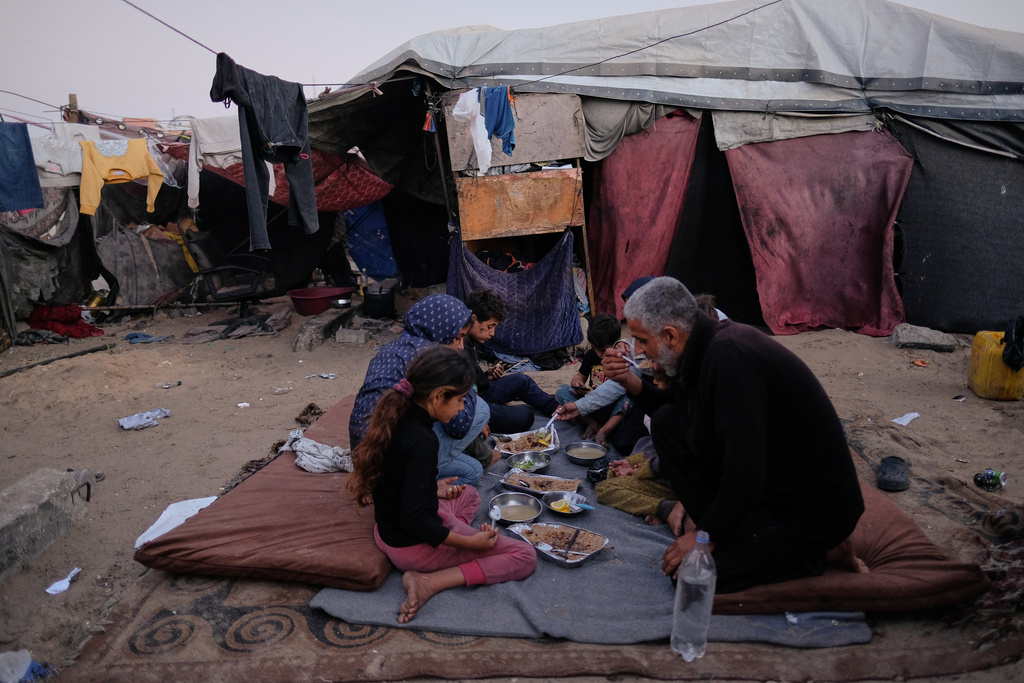 Displaced members of the Al-Zamli family break their fast on the first day of Ramadan inside their tent in Khan Younis, Gaza Strip, Wednesday, Feb. 18, 2026. (AP Photo/Jehad Alshrafi)
