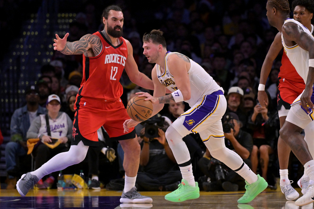 Houston Rockets center Steven Adams (12) guards Los Angeles Lakers guard Luka Doncic during the first half of an NBA basketball game, Thursday, Dec. 25, 2025, in Los Angeles. (AP Photo/Jayne Kamin-Oncea)