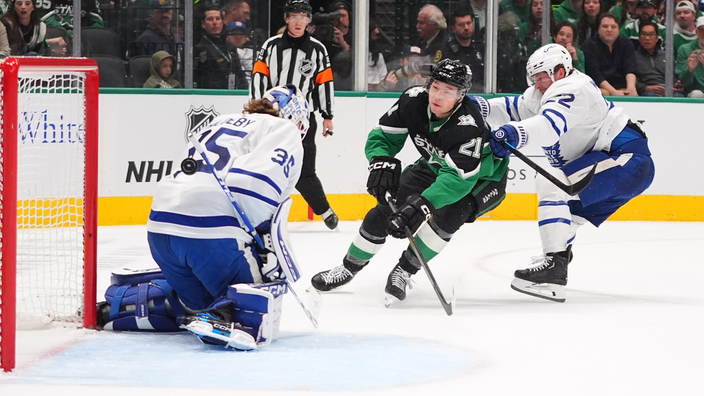 Dallas Stars left wing Jason Robertson (21) scores against Toronto Maple Leafs goaltender Dennis Hildeby (35) and defenseman Jake McCabe (22) during the first period of an NHL hockey game Sunday, Dec. 21, 2025, in Dallas. (AP Photo/LM Otero)