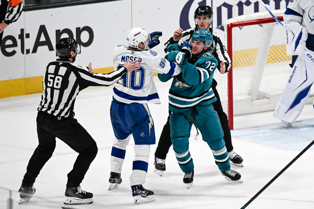 Officials break up a fight between Tampa Bay Lightning defensemen J.J. Moser (90), middle left, and San Jose Sharks left wing William Eklund (72), middle right, during the second period of an NHL hockey game Saturday, Jan. 3, 2026, in San Jose, Calif. (AP Photo/Thien-An Truong)