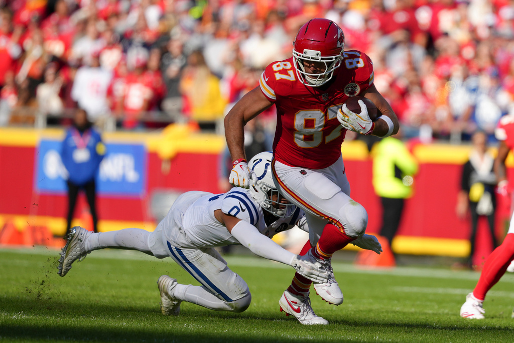 Kansas City Chiefs tight end Travis Kelce (87) is tackled by Indianapolis Colts safety Camryn Bynum (0) during the first half of an NFL football game Sunday, Nov. 23, 2025, in Kansas City, Mo. (AP Photo/Ed Zurga)