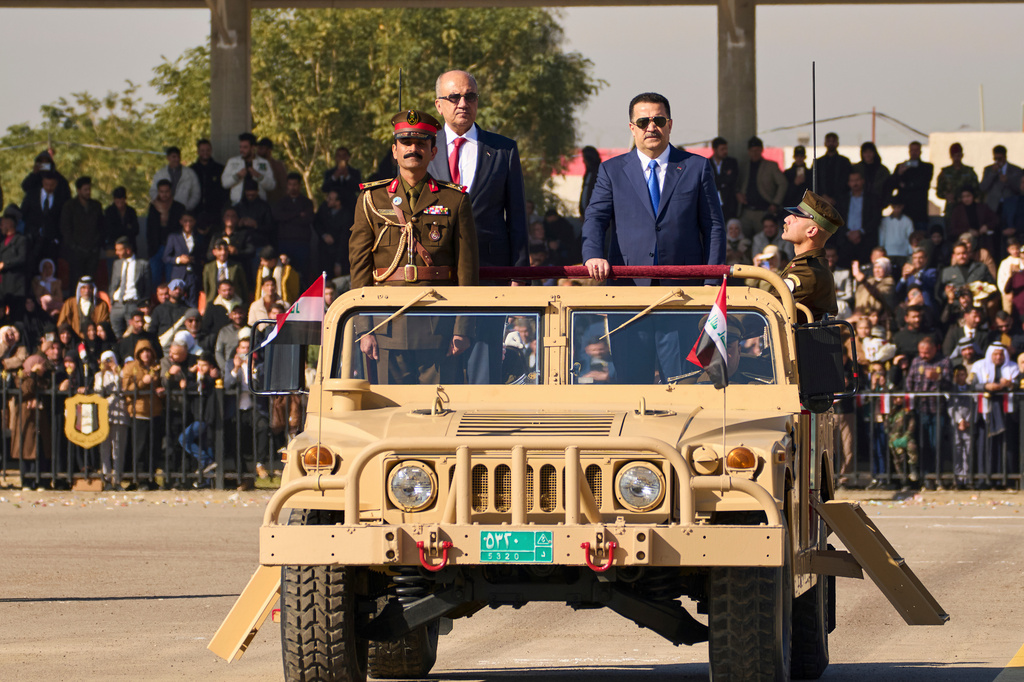 FILE - Iraqi Prime Minister Mohammed Shia al-Sudani, right, rides in a Humvee during the Army Day celebrations, in Baghdad, Iraq, Tuesday, Jan. 6, 2026. (AP Photo/Hadi Mizban, File)