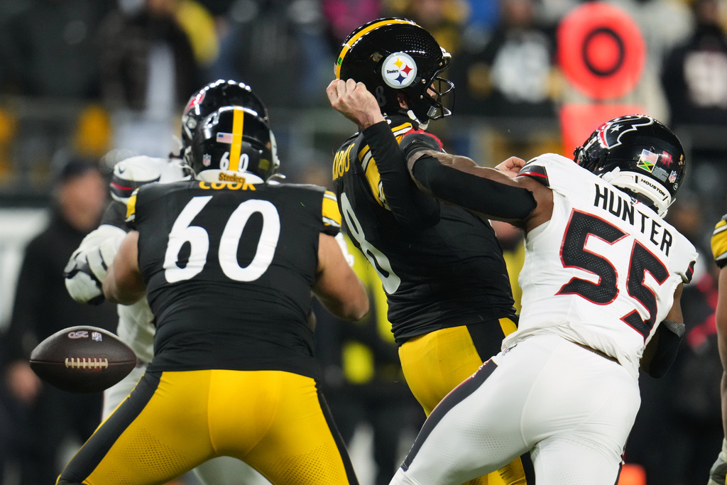 Pittsburgh Steelers quarterback Aaron Rodgers (8) loses possession of the ball while being tackled by Houston Texans defensive end Danielle Hunter (55) during the second half of an NFL wild-card playoff football game, Monday, Jan. 12, 2026, in Pittsburgh. (AP Photo/Gene J. Puskar)