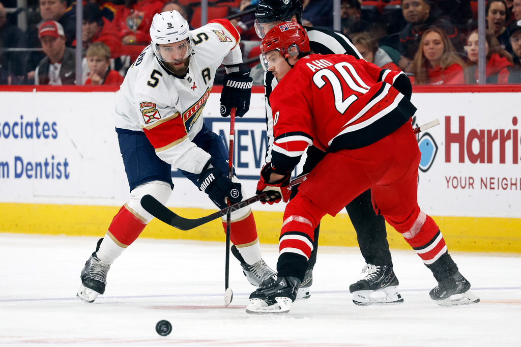FILE - Florida Panthers' Aaron Ekblad (5) wins a face-off against Carolina Hurricanes Sebastian Aho (20) during the third period of an NHL hockey game in Raleigh, N.C., Jan. 16, 2026. (AP Photo/Karl DeBlaker, File)
