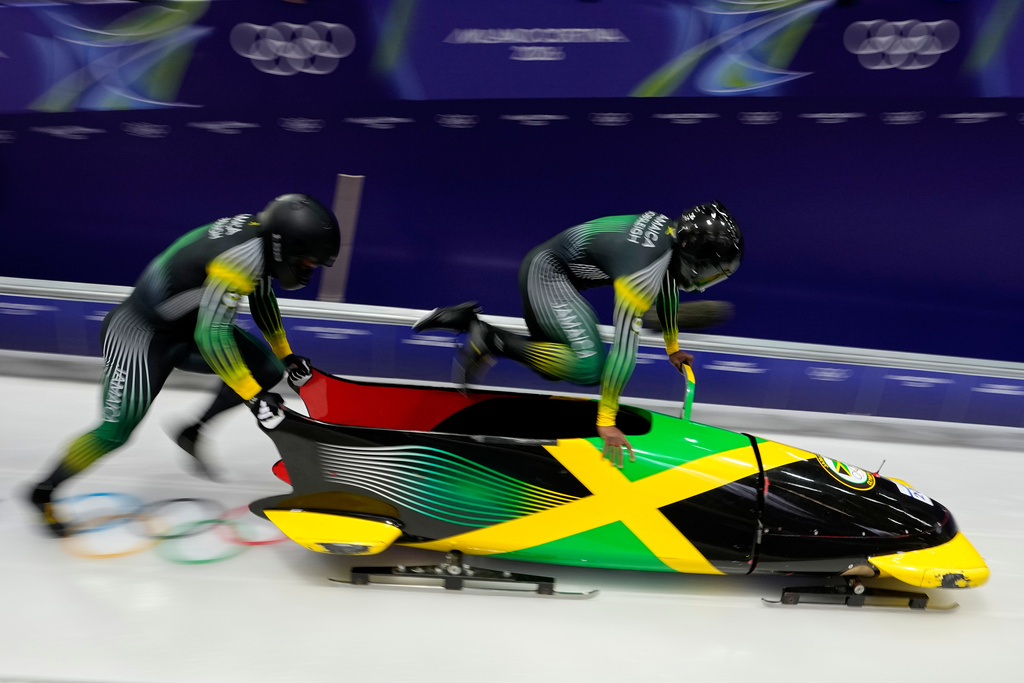 Jamaica's Shane Pitter, right, and Junior Harris start for a two man bobsled run at the 2026 Winter Olympics, in Cortina d'Ampezzo, Italy, Monday, Feb. 16, 2026. (AP Photo/Aijaz Rahi)
