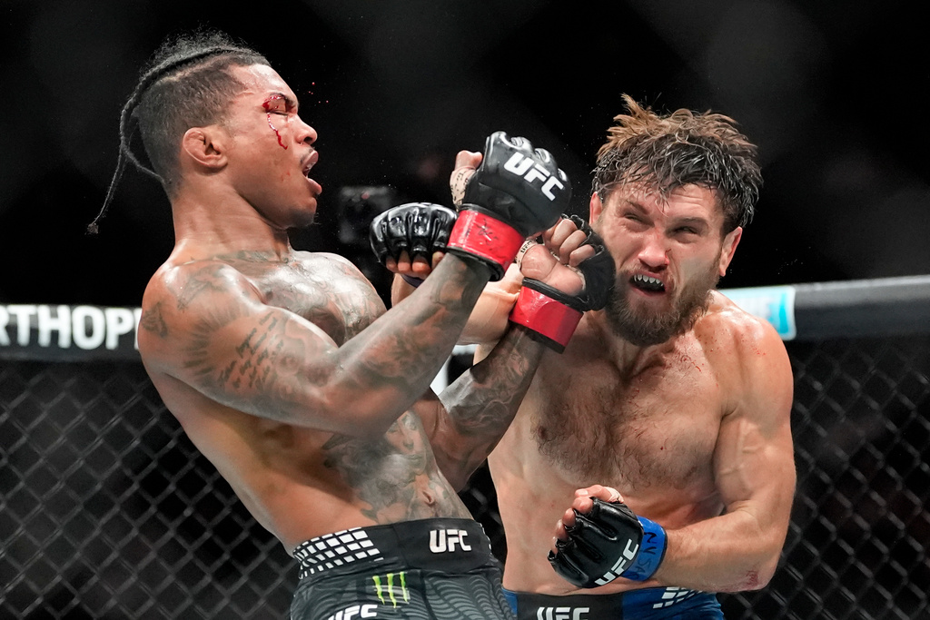 Ethyn Ewing, right, punches Malcolm Wellmaker, left, during the third round of a featherweight bout at the UFC 322 mixed martial arts event, Saturday, Nov. 15, 2025, in New York. (AP Photo/Yuki Iwamura)