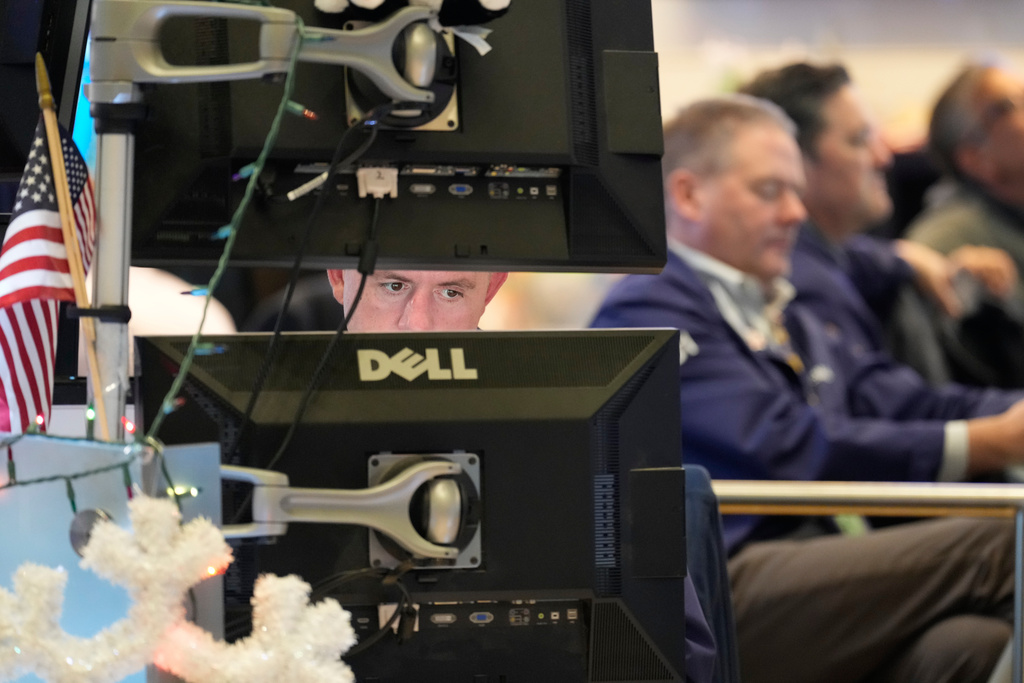 Justin Flinn, left, works on the floor at the New York Stock Exchange in New York, Wednesday, Dec. 10, 2025. (AP Photo/Seth Wenig)