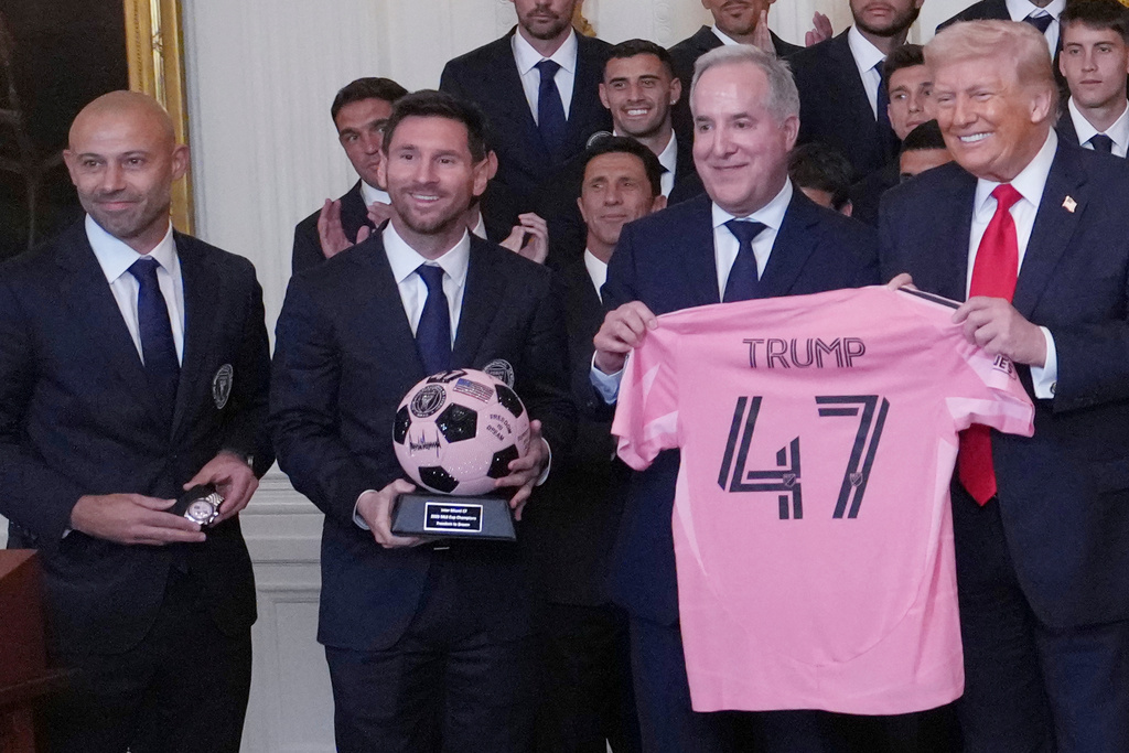 President Donald Trump poses for a photo as head coach Javier Mascherano, Lionel Messi and Inter Miami co-owner Jorge Mas present gifts at an event to honor the 2025 Major League Soccer champions Inter Miami in the East Room of the White House, Thursday, March 5, 2026, in Washington. (AP Photo/Julia Demaree Nikhinson)