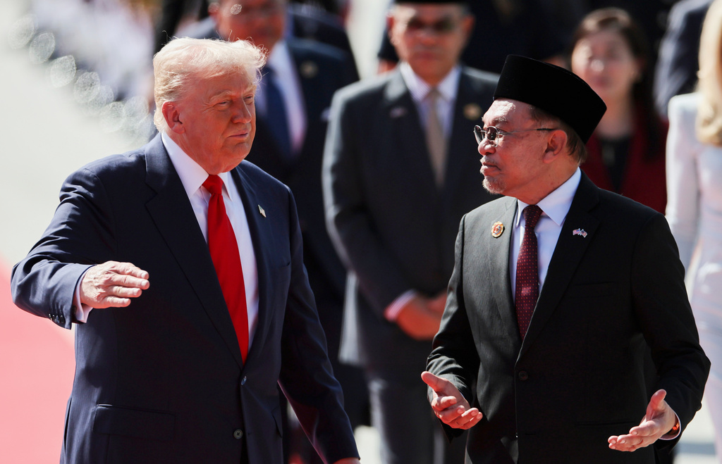 U.S. President Donald Trump talks with Malaysia Prime Minister Anwar Ibrahim as he arrives at Kuala Lumpur International Airport to attend the 47th Association of Southeast Asian Nations (ASEAN) summit in Kuala Lumpur, Malaysia, Sunday, Oct. 26, 2025. (Hasnoor Hussain/Pool Photo via AP)