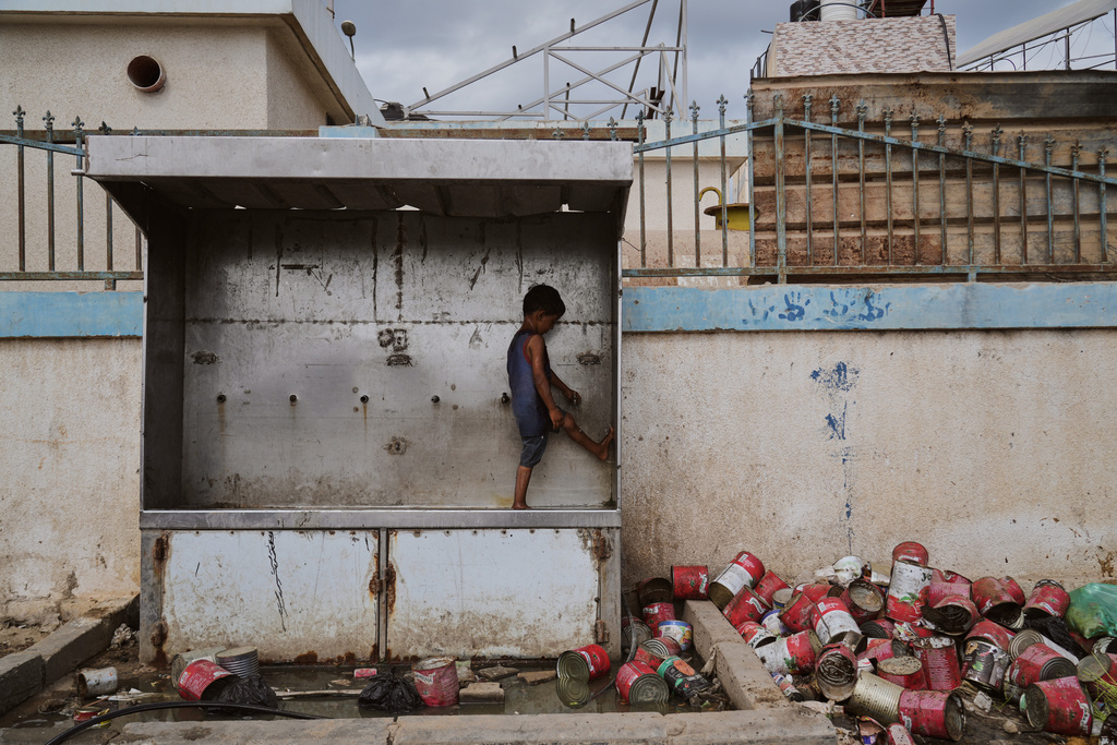 A child plays with water at a camp for displaced Palestinians in Deir al-Balah, Monday, Oct. 6, 2025. (AP Photo/Abdel Kareem Hana)