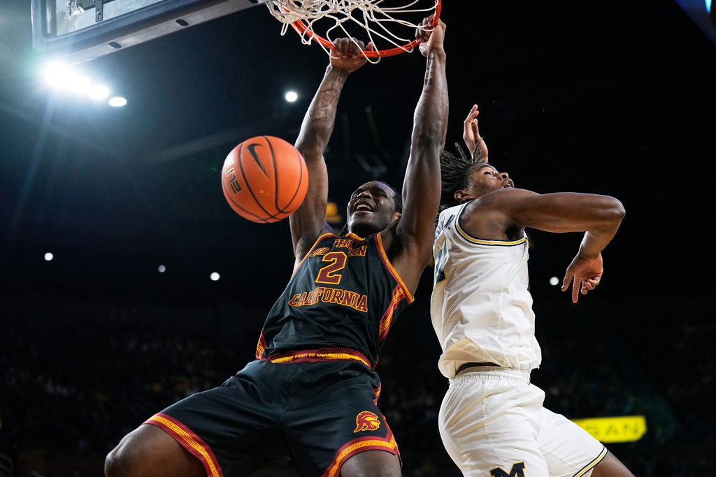 Southern California forward Ezra Ausar, left, reacts after dunking against Michigan forward Morez Johnson Jr. during the first half of an NCAA college basketball game, Friday, Jan. 2, 2026, in Ann Arbor, Mich. (AP Photo/Ryan Sun)