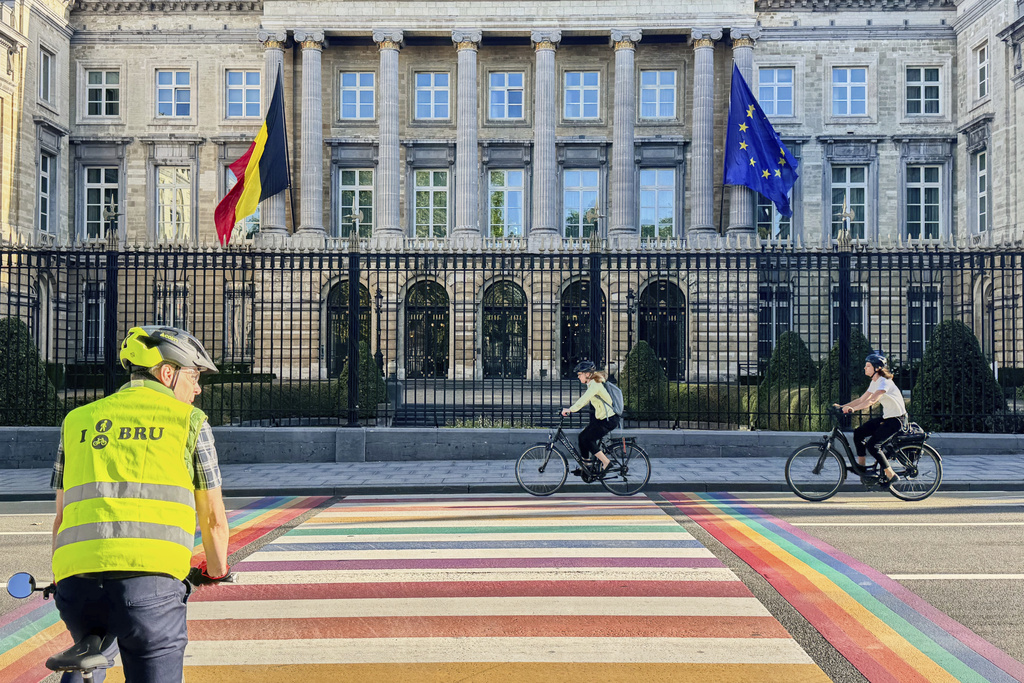 People cycle past the Belgian Parliament in Brussels, Belgium, Tuesday, Sept. 2, 2025. (AP Photo/Sylvain Plazy)