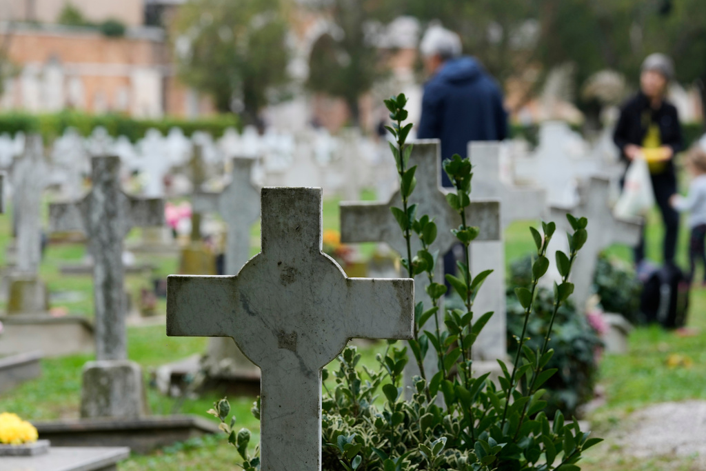 Mourners pay respects to their dead, at the San Michele cemetery, on All Soul's Day, in Venice, Italy, Sunday, Nov. 2, 2025. (AP Photo/Luca Bruno)