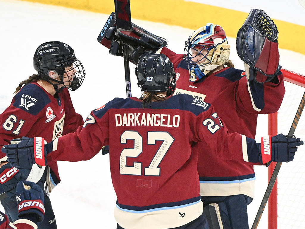 Montreal Victoire goaltender Ann-Renee Desbiens (35) celebrates with teammates Nicole Gosling (61) and Shiann Darkangelo (27) after defeating the Ottawa Charge in a PWHL hockey game in Laval, Que., Tuesday, Jan. 13, 2026. (Graham Hughes/The Canadian Press via AP)