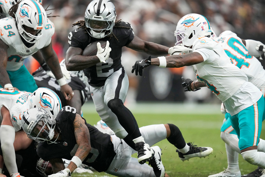 Las Vegas Raiders running back Ashton Jeanty (2) runs from Miami Dolphins cornerback Jason Marshall Jr., right, during the second half of an NFL football game, Sunday, Sept. 13, 2026, in Las Vegas. (AP Photo/Ross D. Franklin)